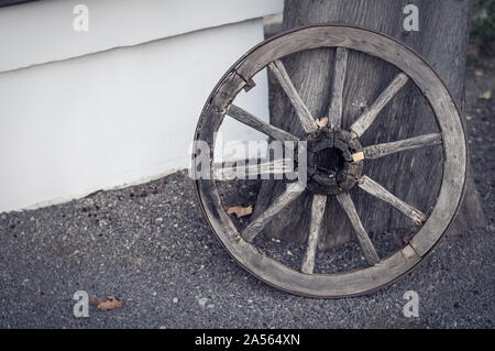 Une vieille roue en bois se trouve au mur de la maison Banque D'Images