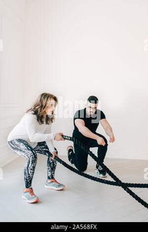 L'observation d'instructrice de conditionnement physique à l'aide de corde en femme bataille studio Banque D'Images