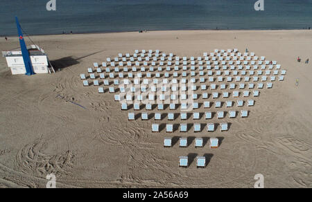 Rostock, Allemagne. 18 Oct, 2019. Sur la plage en face de l'hôtel Neptun un locateur a placé ses chaises de plage en forme de cœur. Avec cette campagne "Pour une excellente saison 2019' il tient à remercier particulièrement les clients de l'hôtel Neptun, qui peut regarder ce coeur d'en haut. (Photographie aérienne avec drone) Crédit : Bernd Wüstneck/dpa-Zentralbild/ZB/dpa/Alamy Live News Banque D'Images