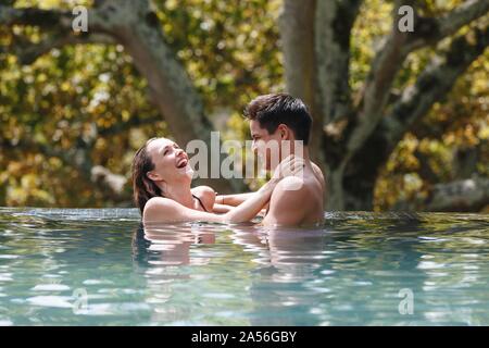 Couple laughing in swimming pool Banque D'Images