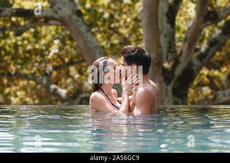 Couple kissing in swimming pool Banque D'Images