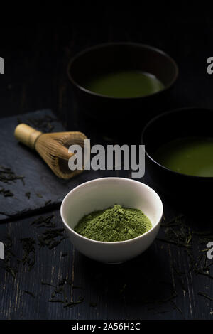 Still Life of thé matcha préparation avec un fouet, et de bols de thé matcha et de thé en poudre, clé faible Banque D'Images