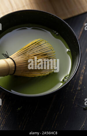 Still Life of thé matcha préparation avec un fouet, dans un bol de thé matcha, Close up, overhead view Banque D'Images