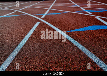 Surface d'athlétisme avec des lignes blanches et orange de gravier. Banque D'Images