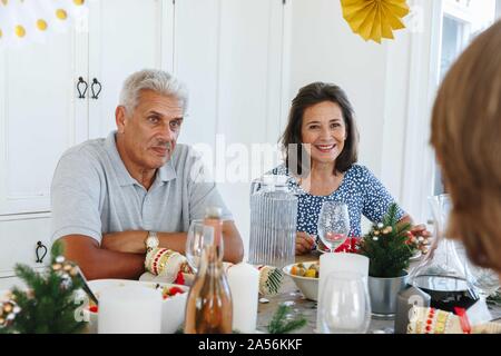 Senior couple talking with family at home party Banque D'Images