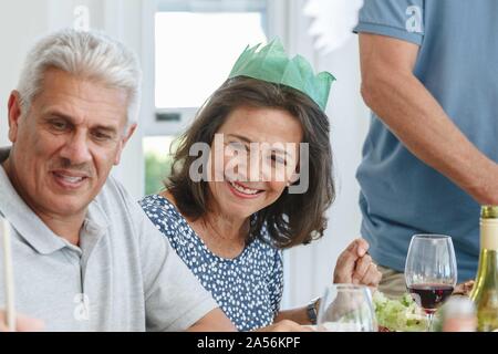 Senior couple écoute attentivement à table à manger en home party Banque D'Images