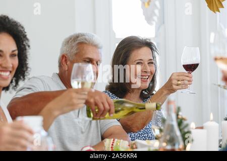 Family toasting wine at home party Banque D'Images