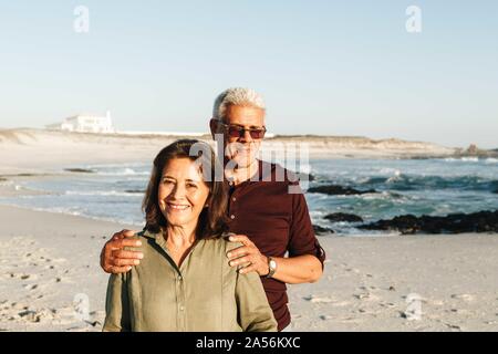 Senior couple enjoying sun on sandy beach Banque D'Images