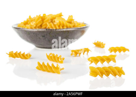 Beaucoup d'aliments complets secs fusilli dans dark brown Bol en céramique isolé sur fond blanc Banque D'Images