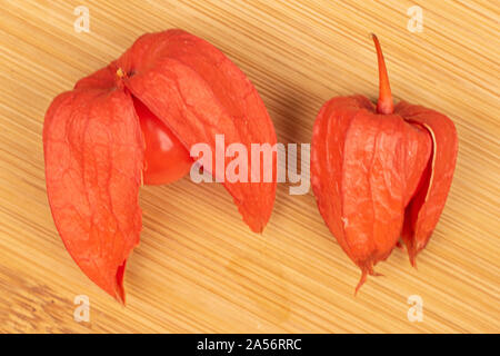Groupe de deux entiers et frais flatlay physalis orange sur des meubles en bois Banque D'Images