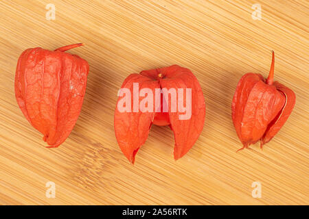 Groupe de trois entiers et frais flatlay physalis orange sur des meubles en bois Banque D'Images