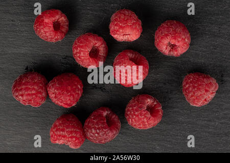 Groupe de onze entiers et frais, framboise rouge sur flatlay pierre gris Banque D'Images