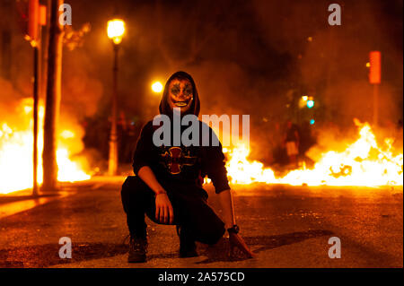 Barcelone, Espagne - 18 octobre 2019 : manifestation catalane avec masque de joker se tenir en face du feu au cours des émeutes avec police mossos de nuit avec atmosp creepy Banque D'Images