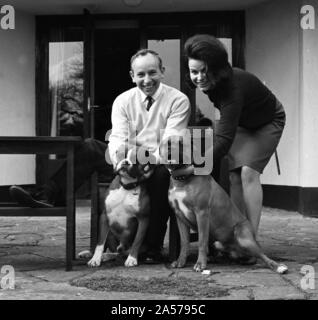 John Surtees se détend à la maison avec sa femme et des chiens de compagnie en 1966. Banque D'Images