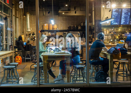 Les clients travailler et profiter de la connexion Wi-Fi gratuite dans un café à Chelsea à New York le mardi, Octobre 15, 2019. Le wi-fi et les tables communes encouragent l'utilisation de la cafétéria comme un espace de co-working. (© Richard B. Levine) Banque D'Images