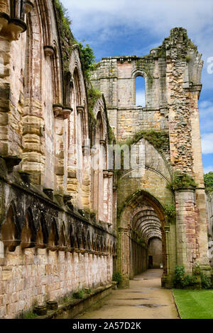 Corridor intérieur humide et érodée arches à la nef de l'abbaye de Fountains ruines de l'église monastère cistercien au nord Yorkshire Angleterre Banque D'Images