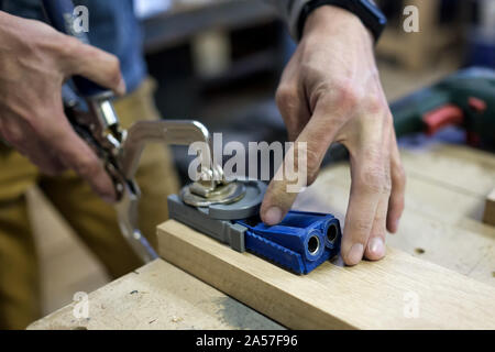 Carpenter installe les meubles charnière. Trou poche concept menuiserie. Banque D'Images