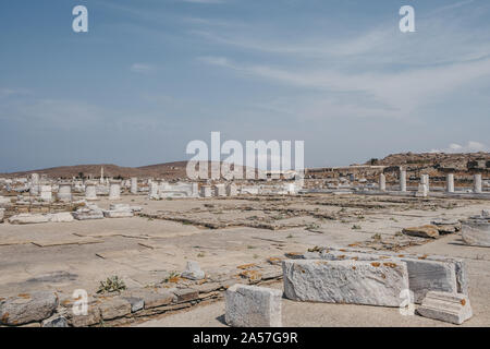 Ruines de l'agora sur l'île historique de Délos, en Grèce, Musée archéologique de Delos sur l'arrière-plan. Banque D'Images