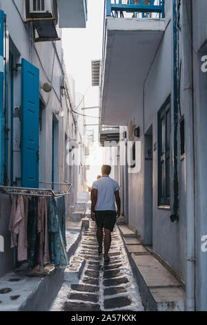 Mykonos, Grèce - 23 septembre 2019 : vue arrière de personnes marchant dans une rue étroite dans la ville de Mykonos (Hora), capitale de l'île et l'un des meilleurs Banque D'Images