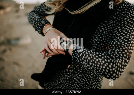 Femme tenant des bracelets sur la plage Mala Banque D'Images