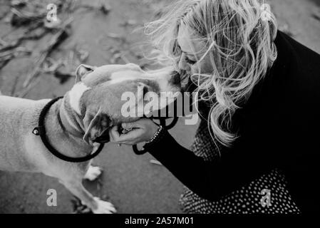 Woman kissing son chien sur la plage Banque D'Images