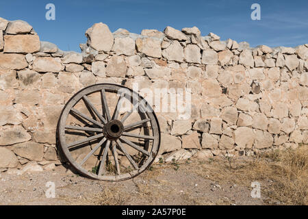 Roue de chariot et les restes d'un vieux mur du 20e siècle, période où ce qui est maintenant l'Hueco Tanks State Historic Area près d'El Paso de El Paso County, Texas, était un ranch privé Banque D'Images