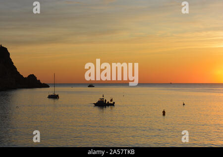 Yacht et bateau de plongée ancré à la pointe, Cabo de la Nao, silhouette au lever du soleil Banque D'Images