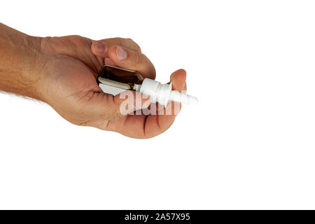 Main tient une petite bouteille avec un pulvérisateur. Banque D'Images