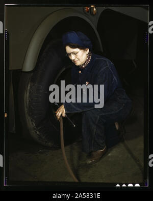 Les travailleurs de la production de guerre à l'Heil Société remorque l'essence des réservoirs pour l'US Army Air Corps, Milwaukee, Wisconsin Mme Angeline Kwint, 45 ans, un ex-femme au foyer, contrôle les pneus de remorques. Son mari et son fils sont dans l'Armée américaine Banque D'Images