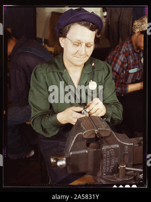 La production de guerre au travailleur Vilter [Fabrication] Société M5 et M7 des fusils pour l'armée américaine, Milwaukee, Wisconsin Ex-femme au foyer, l'âge de 49 ans, en train de faire, travail à la table sur les petites pièces d'armes à feu. Fils [est] Deuxième L[t]ieutenan, gendre, le Capt[ain] à l'Armée Banque D'Images