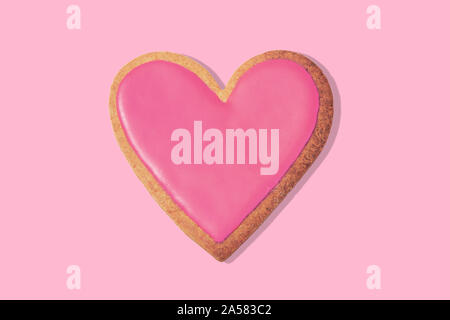 Cookie en forme de cœur Décoré sur fond rose, vue du dessus. Concept d'amour Banque D'Images