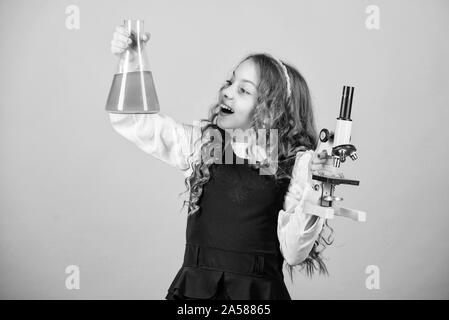 La recherche scientifique en laboratoire. Petite fille avec microscope. étude de l'enfant bilogy leçon. Découvrez l'avenir. retour à l'école. L'éducation connaissances. petite fille scientifique avec ballon d'essai. L'échantillon biologique. Banque D'Images