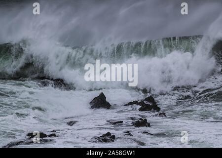 Forte vague qui arrive et qui éclabousse les pierres dans la vague de 'Cribber', Newquay, Cornwall, Royaume-Uni Banque D'Images