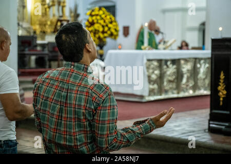 Homme qui prie, dans la Basilique de Notre Dame de Candelaria, Medellín, Colombie Banque D'Images