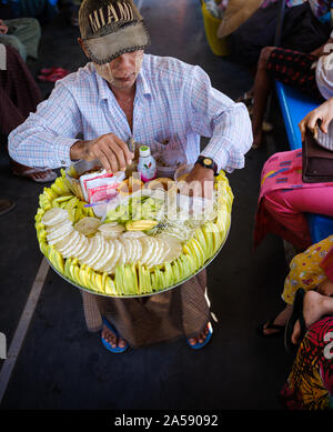 YANGON, MYANMAR - CIRCA DÉCEMBRE 2017 : vendeur de fruits au service ferroviaire circulaire de Yangon. Banque D'Images