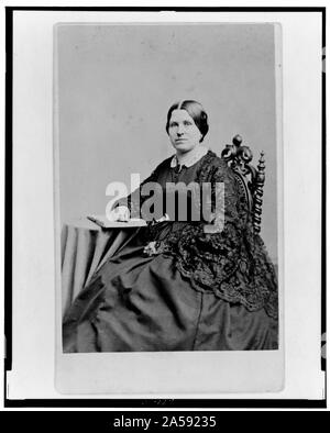 Femme non identifiée, trois-quarts, portrait assis avec main sur livre, orienté vers la gauche Banque D'Images