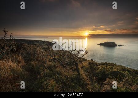 Coucher de soleil à couper le souffle sur la mer avec une petite colline au coin de nAre Head, Cornwall, Royaume-Uni Banque D'Images