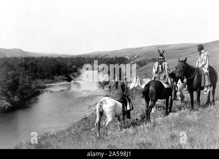 Edward S. Curits indiens des États-Unis - trois Indiens Piegan et quatre chevaux sur la colline au-dessus de river ca. 1910 Banque D'Images