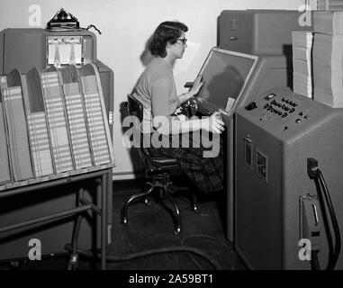 Un membre du personnel de la Section d'informatique au National Advisory Committee for Aeronautics (NACA) Lewis Flight Propulsion Laboratory exploite un International Business Machines (IBM) telereader à la 8- par 6 pieds de soufflerie supersonique. Banque D'Images