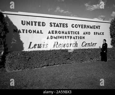 Un garde de sécurité examine le nouveau panneau près de l'entrée du Centre de recherche Lewis un jour après que la National Aeronautics and Space Administration (NASA) a été officiellement créé. La NASA a été mise en place le 1er octobre 1958, et le National Advisory Committee for Aeronautics (NACA) Lewis Flight Propulsion Laboratory de la NASA Lewis est devenu le centre de recherche. Banque D'Images