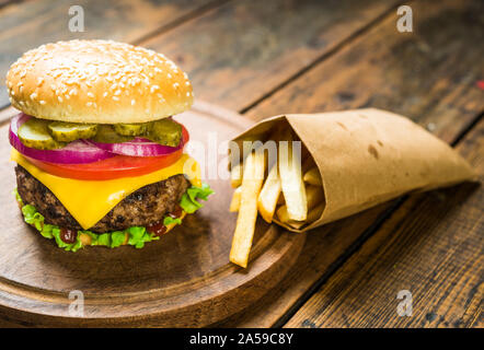 Cheese burger et frites contre fond de bois. De savoureux repas rapides. Banque D'Images