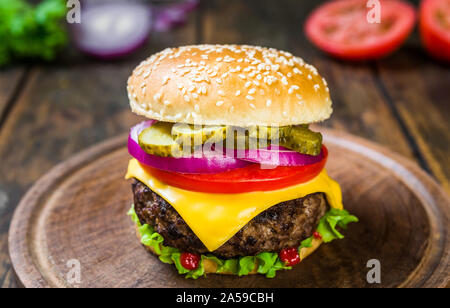 Burger au fromage avec du fromage contre fond de bois. De savoureux repas rapides. Banque D'Images