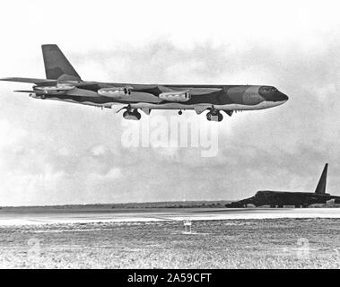 1972 - UN B-52 Stratofortress attend d'avion à côté de la piste comme un B-52G des approches pour l'atterrissage après avoir terminé une mission de bombardement sur le Nord du Vietnam au cours de l'opération LINEBACKER. Banque D'Images