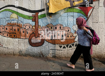 Une femme palestinienne passe devant un tableau mural montrant la "clé du retour", symbole palestinien de soutien au droit de retour des Palestiniens qui ont été expulsés de leur maison pendant la guerre de 1948 avec Israël à Ramallah, ville palestinienne dans le centre de la Cisjordanie dans les territoires palestiniens Banque D'Images