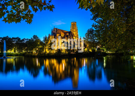 L'Allemagne, de la célèbre église de St Jean, un bâtiment d'église gothique à stuttgart feuersee, éclairé par nuit dans le centre de l'eau du lac reflète par Banque D'Images