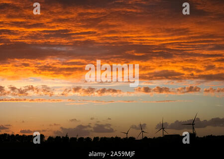 Éoliennes dans le paysage hollandais au-dessous d'un ciel coloré au coucher du soleil spectaculaire Banque D'Images