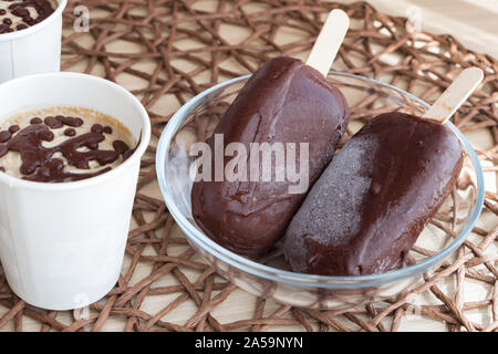 Dessert végétalien sain. Douceurs maison inoffensifs. La crème glacée banane crue avec la crème de coco, avec chocolat, dans une tasse de papier blanc, et Banque D'Images
