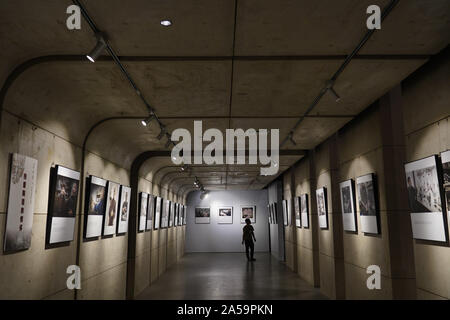 (191019) -- JINGDEZHEN, 19 octobre 2019 (Xinhua) -- un homme visite une exposition de photos lors d'une foire de la céramique de Jingdezhen, Chine dans l'est de la Province du Jiangxi, le 18 octobre 2019. Les cinq jours, 2019 Chine Jingdezhen Céramique International juste ouvert le vendredi, attirant près de 1 000 entreprises de porcelaine au pays et à l'étranger. (Xinhua/Zhou Mi) Banque D'Images