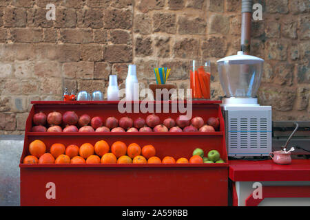 Bar à jus à la rue - jus de fruits frais réfrigérés dans des gobelets en plastique, une rue populaire de la nourriture dans la ville d'Acre en Israël Banque D'Images