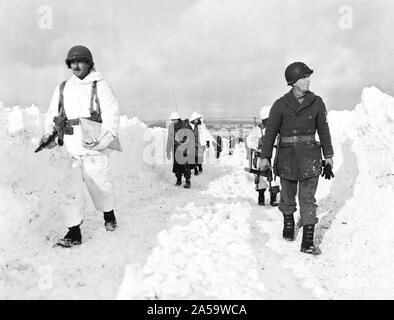 Légende originale : fantassins américains d'une division blindée de mars une route au sud-est de naissance, Belgique. Remarque La hauteur de l'amoncellement de neige de chaque côté de la route. 1/22/45. Co. C, 23e Armd. Inf, bn., 7e Armd. Banque D'Images